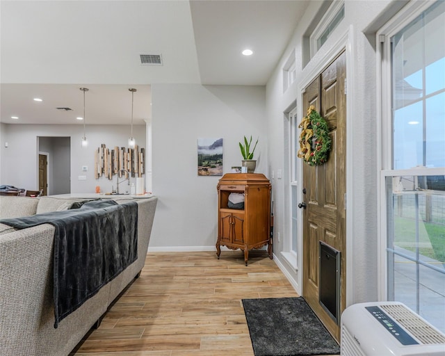 interior space featuring hanging light fixtures, sink, and light hardwood / wood-style floors