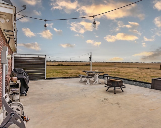 view of patio / terrace featuring a rural view, a fire pit, and area for grilling