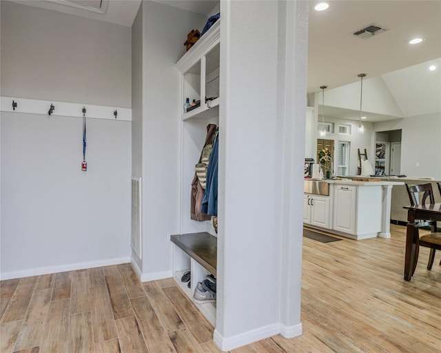 mudroom featuring vaulted ceiling and light wood-type flooring