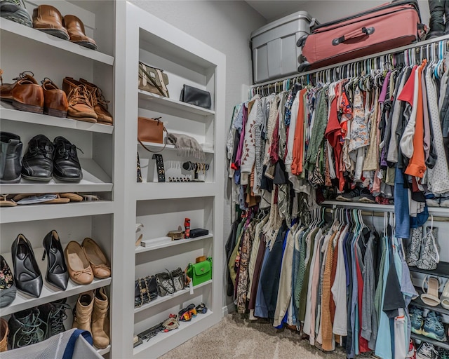 walk in closet featuring light colored carpet