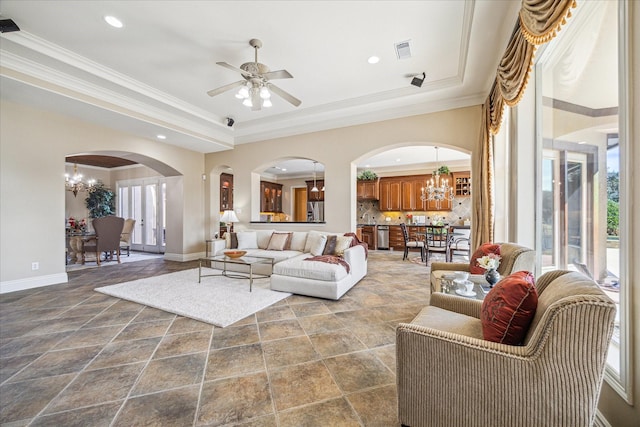 living room featuring a raised ceiling, ornamental molding, and a healthy amount of sunlight