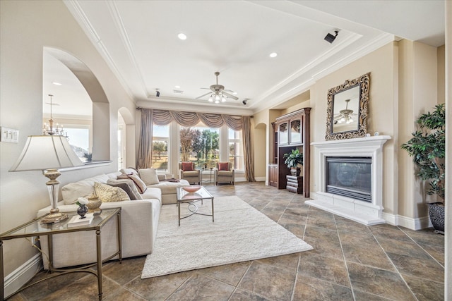 living room with crown molding, ceiling fan, and a tray ceiling