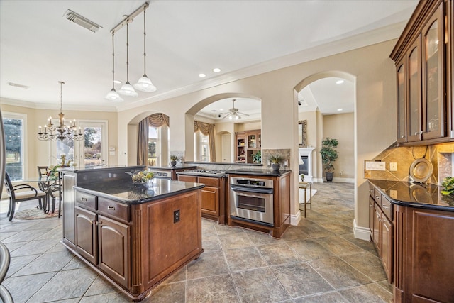 kitchen with stainless steel oven, ornamental molding, kitchen peninsula, pendant lighting, and decorative backsplash