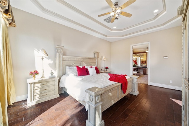 bedroom featuring dark wood-type flooring, ceiling fan, a tray ceiling, and crown molding