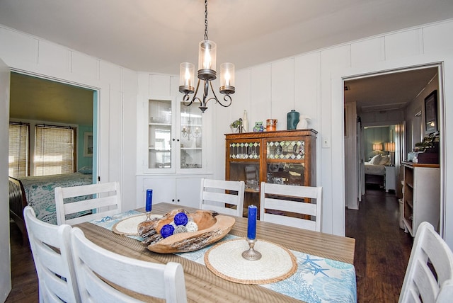 dining area with dark hardwood / wood-style flooring and a notable chandelier