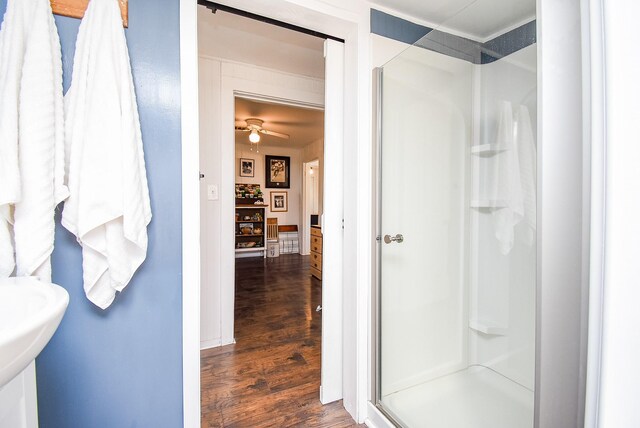 bathroom featuring hardwood / wood-style flooring, ceiling fan, and walk in shower