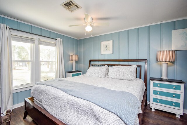 bedroom with dark wood-type flooring, ornamental molding, and ceiling fan