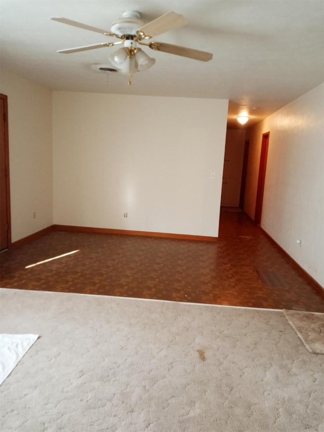 empty room with ceiling fan and dark parquet floors