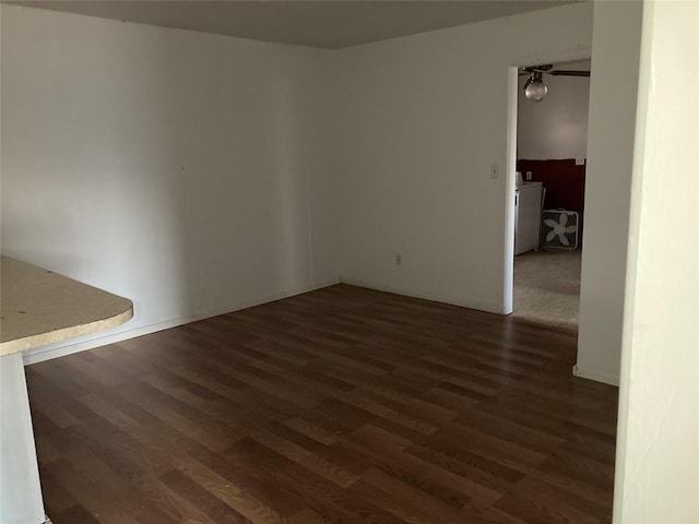 spare room featuring dark hardwood / wood-style flooring and washer / dryer