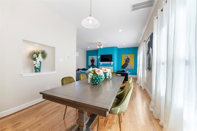 dining space with ceiling fan and light wood-type flooring