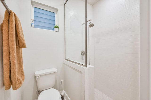 bathroom featuring a tile shower and toilet