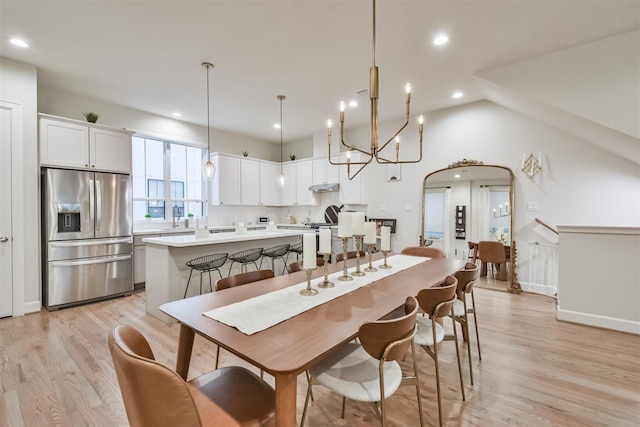 dining room with arched walkways, baseboards, lofted ceiling, light wood-style flooring, and recessed lighting