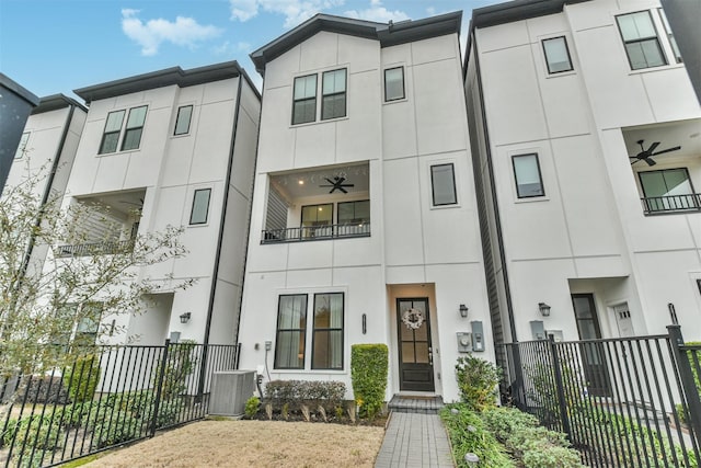 multi unit property featuring central air condition unit, ceiling fan, fence, and stucco siding