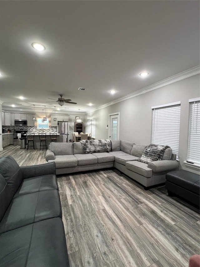 living room featuring crown molding, ceiling fan, and hardwood / wood-style flooring