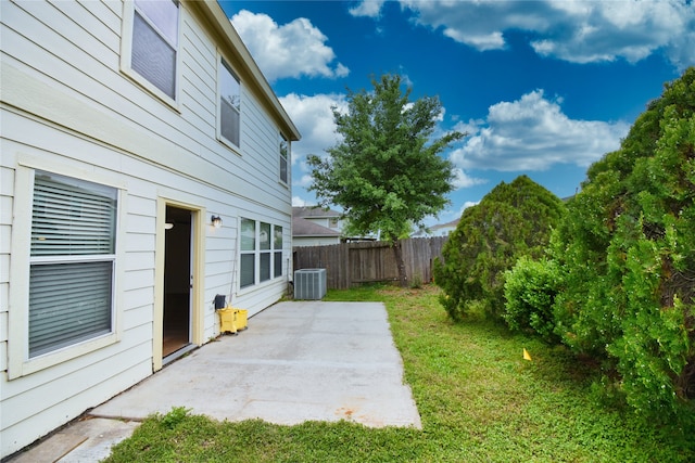 view of yard with central AC and a patio