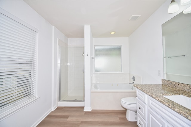 full bathroom featuring vanity, hardwood / wood-style floors, shower with separate bathtub, and toilet