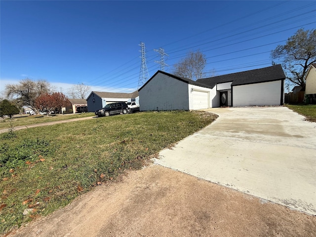 view of side of property with a garage and a lawn