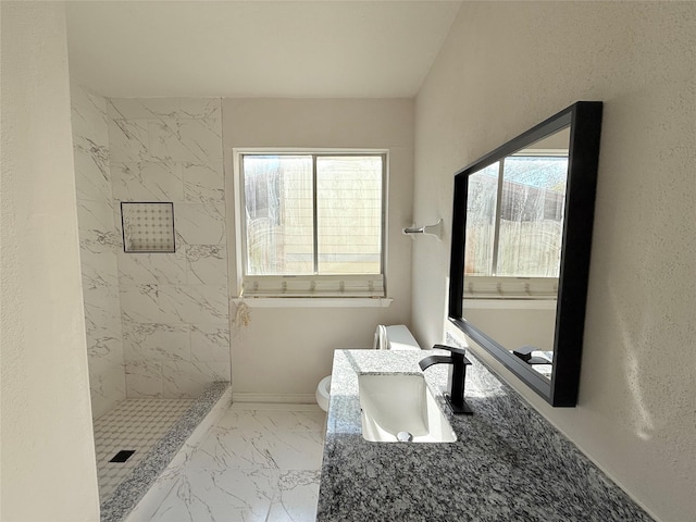 bathroom featuring vanity, toilet, and tiled shower