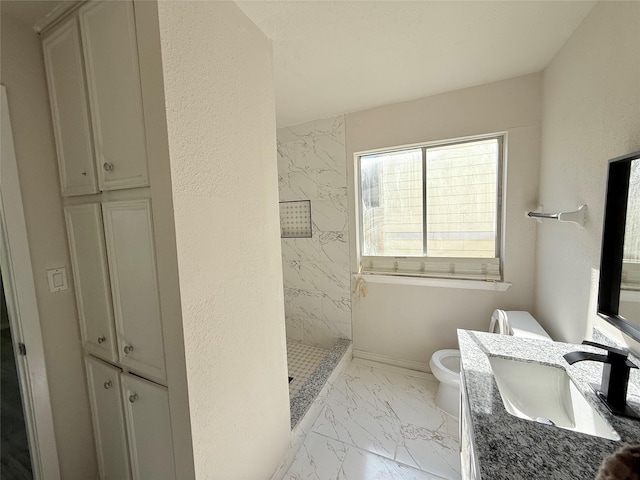 bathroom featuring tiled shower, vanity, and toilet