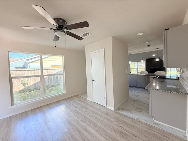 spare room featuring ceiling fan, plenty of natural light, and light wood-type flooring