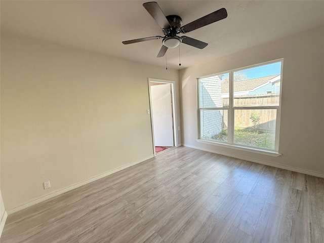 empty room with ceiling fan and light hardwood / wood-style flooring