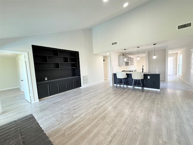 unfurnished living room featuring light hardwood / wood-style flooring and vaulted ceiling