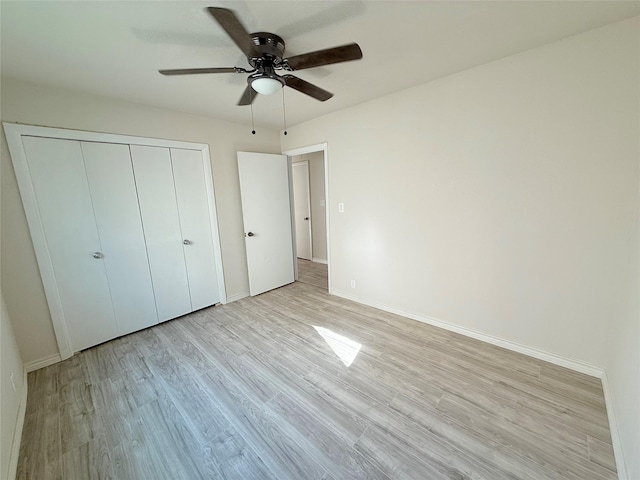 unfurnished bedroom featuring ceiling fan, a closet, and light hardwood / wood-style flooring