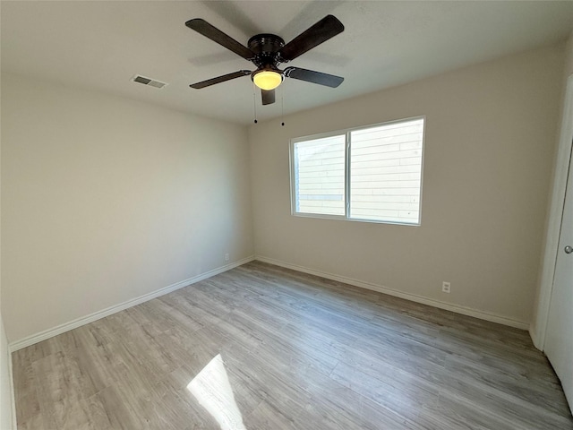 spare room with ceiling fan and light wood-type flooring