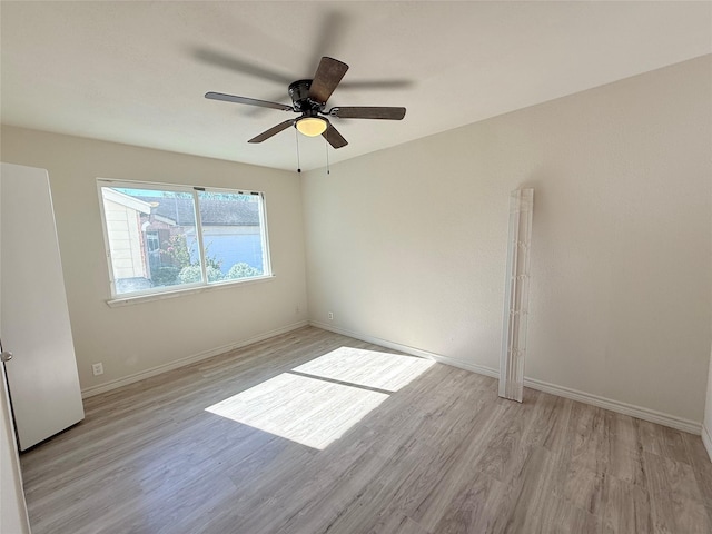 spare room with ceiling fan and light wood-type flooring