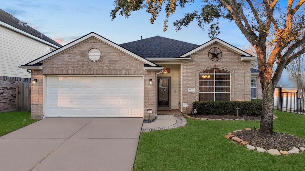 view of front facade featuring a garage and a lawn