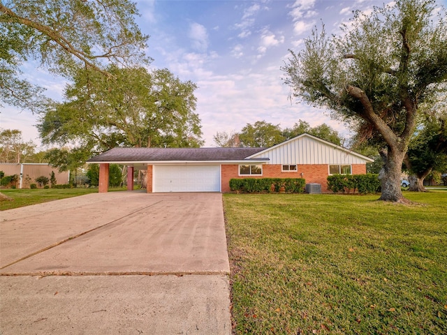 ranch-style house with a garage, a front yard, and central air condition unit