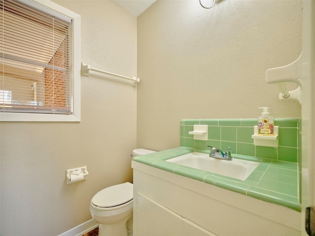 bathroom with tasteful backsplash, vanity, and toilet