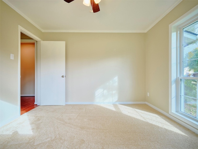 carpeted empty room featuring crown molding, ceiling fan, and plenty of natural light