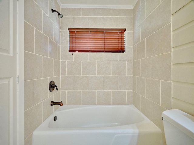 bathroom with crown molding, tiled shower / bath, and toilet