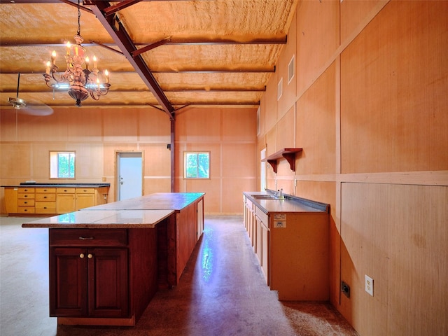 kitchen with concrete flooring, plenty of natural light, sink, and pendant lighting