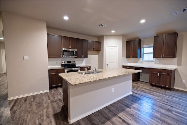 kitchen with dark hardwood / wood-style floors, sink, stainless steel appliances, dark brown cabinets, and a center island with sink