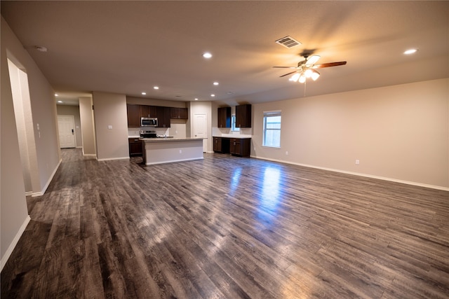 unfurnished living room featuring dark wood-type flooring and ceiling fan