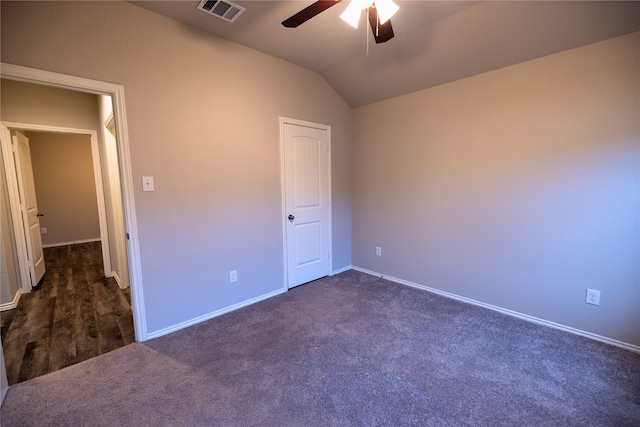 unfurnished bedroom with ceiling fan, lofted ceiling, and dark colored carpet