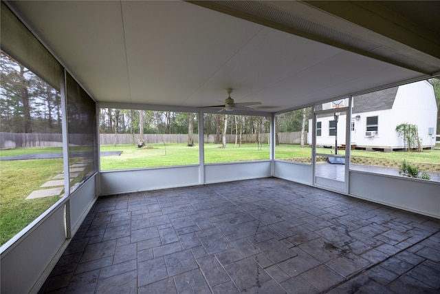 unfurnished sunroom featuring ceiling fan and a healthy amount of sunlight