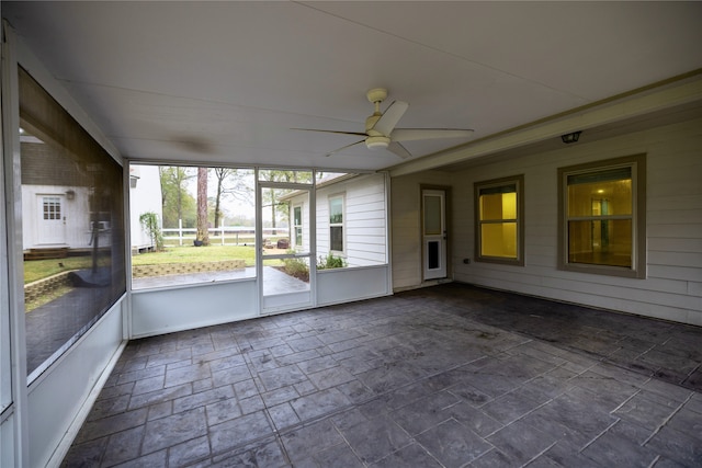 unfurnished sunroom with ceiling fan