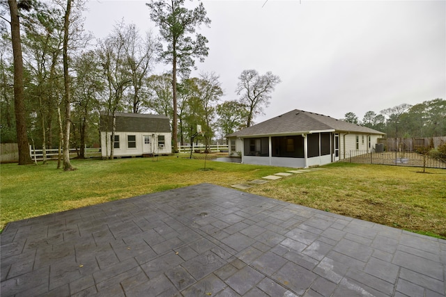 rear view of property with a sunroom, an outbuilding, and a lawn