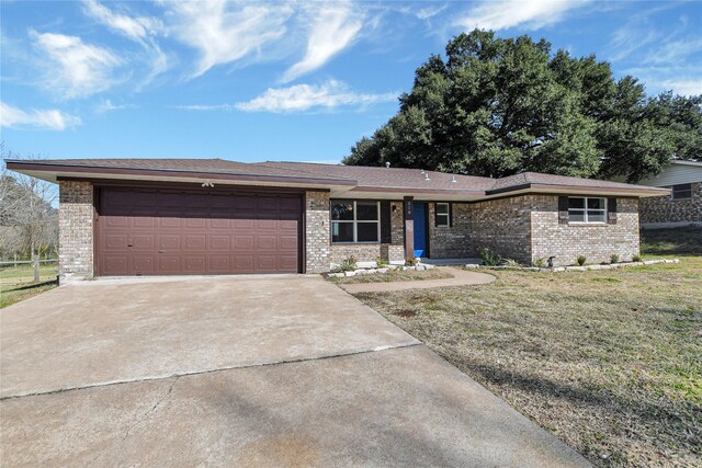 ranch-style home with a garage and a front lawn