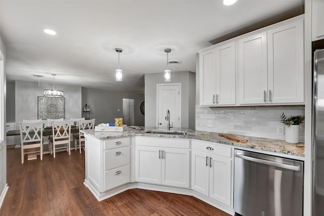 kitchen featuring dishwasher, sink, hanging light fixtures, and white cabinets