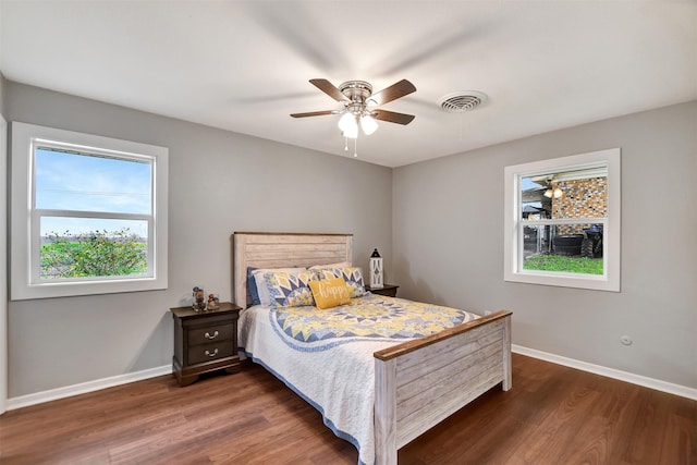 bedroom with dark hardwood / wood-style flooring and ceiling fan