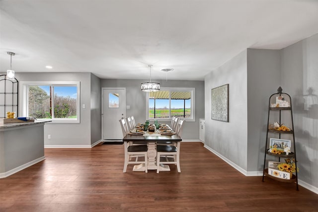 dining space with plenty of natural light, dark hardwood / wood-style flooring, and a chandelier