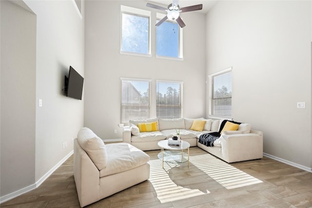 living room featuring ceiling fan and a high ceiling