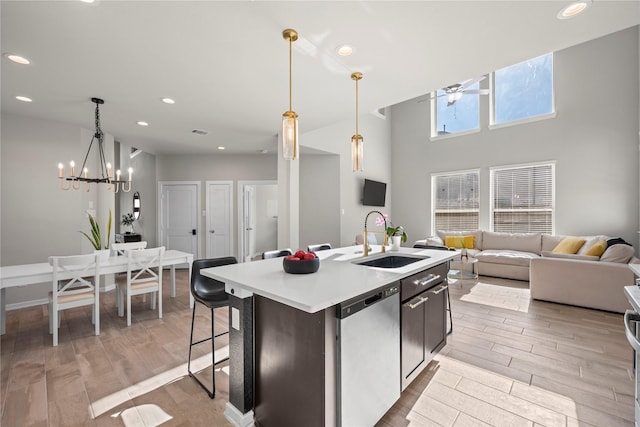 kitchen with decorative light fixtures, sink, a kitchen island with sink, stainless steel dishwasher, and ceiling fan