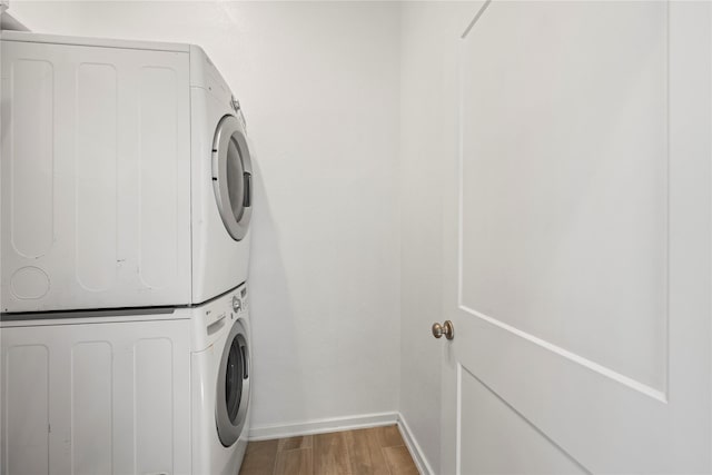 laundry room featuring stacked washer and dryer and hardwood / wood-style floors