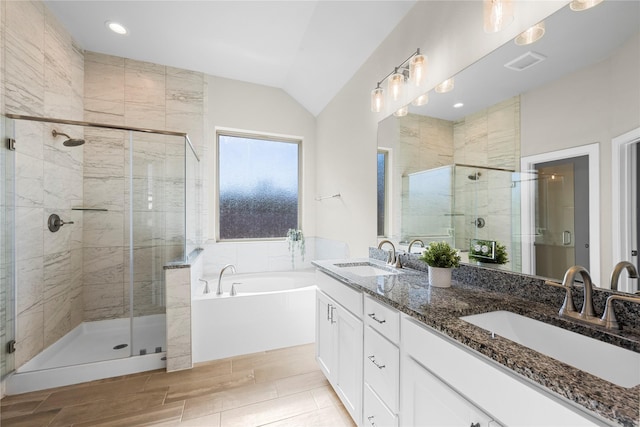 bathroom featuring plus walk in shower, vaulted ceiling, and vanity