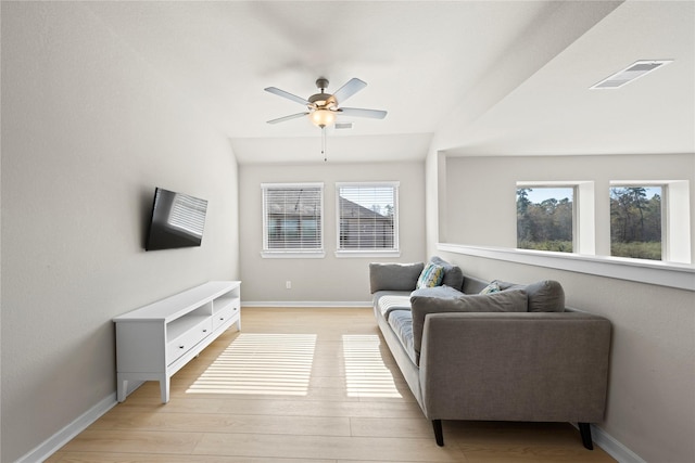 living room with a wealth of natural light, ceiling fan, and light hardwood / wood-style floors